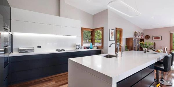 Modern kitchen with a large white island and wood flooring.