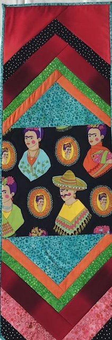 'Frida and Friends' are the center of this wall hanging, which has a hanging sleeve. Measures 12.5 i