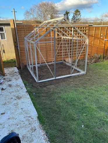 greenhouse frame assembled on breeze block base, Shepton Mallet
