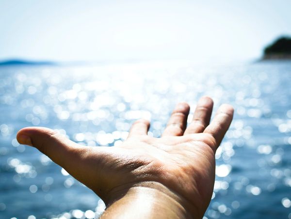 Outstretched hand reaching out Towards the sea.