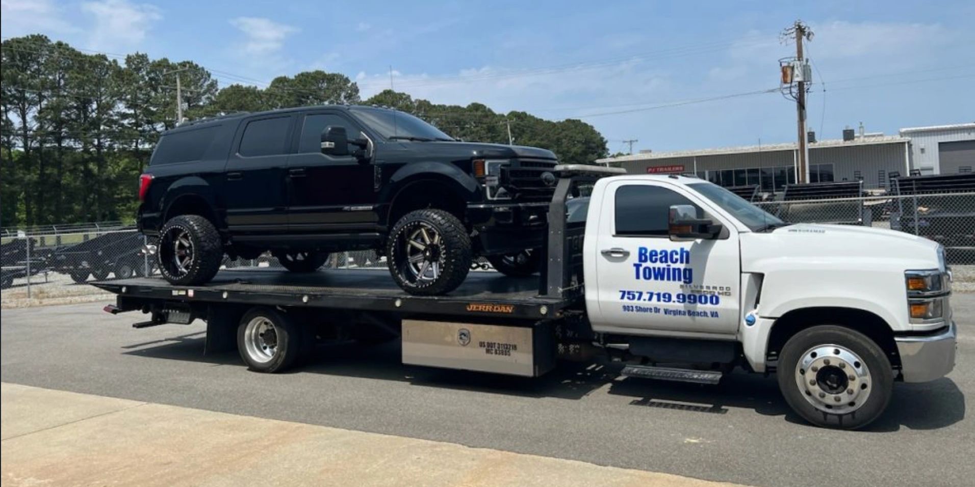 A tow truck carrying a black SUV in Virginia Beach.