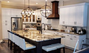 Transitional kitchen with oversized island, granite counters, and custom wood hood
