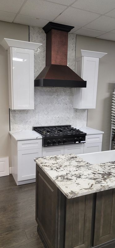 White shaker kitchen with black range and marble-style backsplash