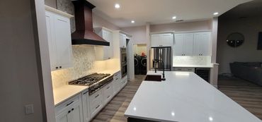 Open-concept kitchen with large island and custom wood vent hood