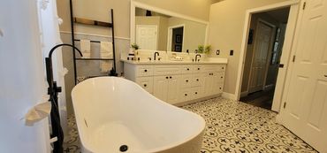 Primary bathroom with freestanding tub and patterned tile floors