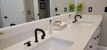 Bathroom vanity detail with quartz countertop and black faucet