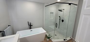 Frameless glass shower with black fixtures and modern tile