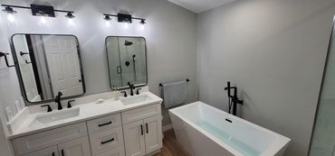 White bathroom with glass shower, vanity, and tub combination