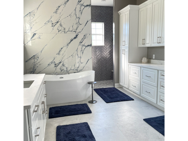 Modern bathroom with marble-look tile, soaking tub, and glass shower