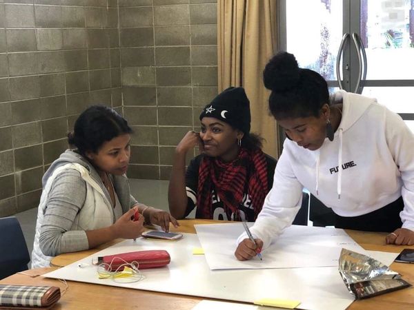 Three young female immigrants engaging in a workshop