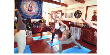 Group yoga class practicing side stretches on blue mats indoors.
