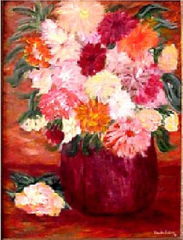 Colorful bouquet of flowers in a red vase with one flower on the table.
