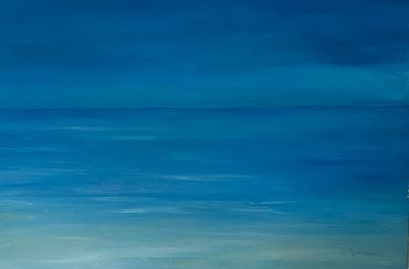 A serene seascape with calm blue water blending into the sky.