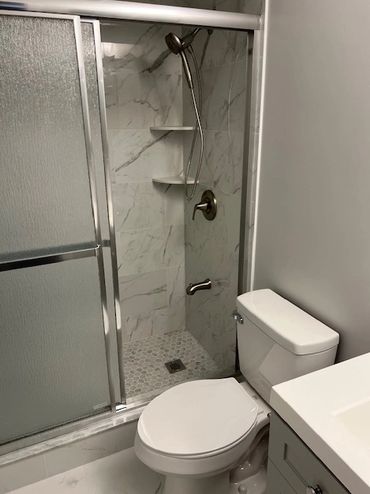 Modern bathroom with a glass shower door and white toilet.