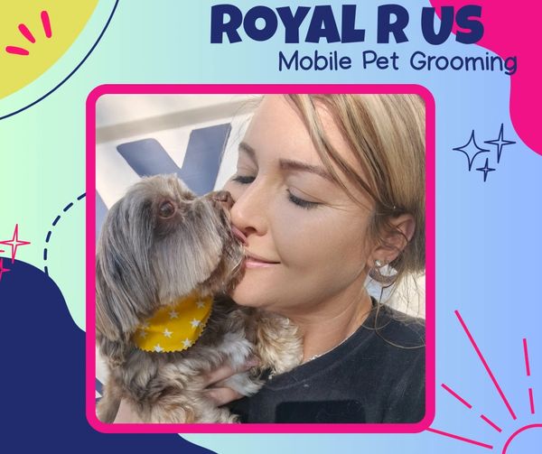Woman lovingly holding a small dog with a yellow star bandana for mobile pet grooming.