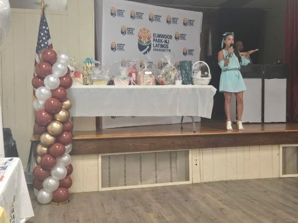 Woman speaking on stage at Elmwood Park event.