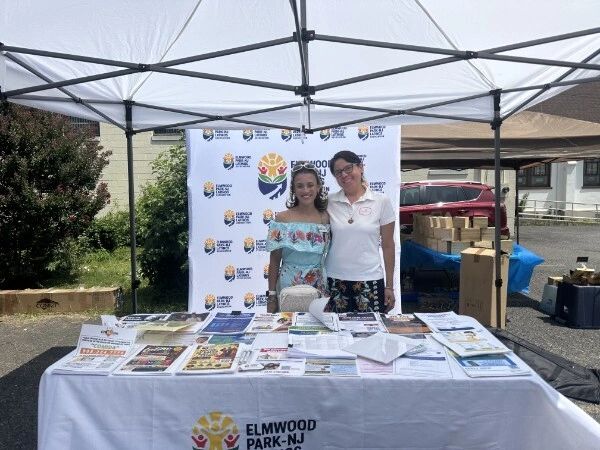 Two women at Elmwood Park-NJ information booth under a tent.