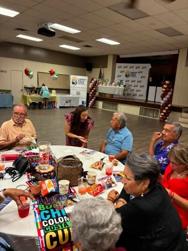 Group enjoying a social gathering around a table with snacks and drinks.