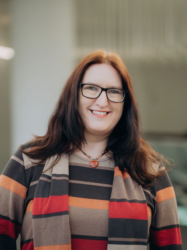 Image of smiling woman wearing a striped top and glasses.