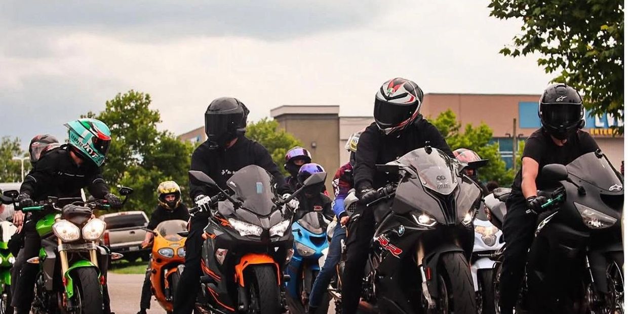 Group of motorcyclists wearing helmets riding sport bikes on a road.