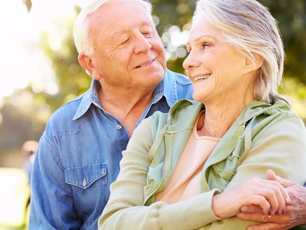 Senior couple smiling and embracing.