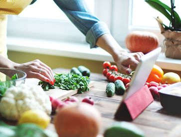 Caregiver assisting a senior with a laptop.