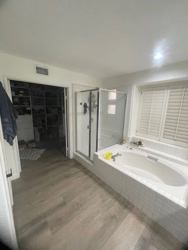 Modern bathroom with a large bathtub and glass shower enclosure.
