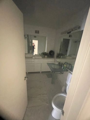 Modern bathroom with glass sink and open doorway.