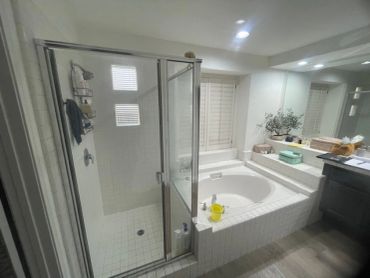 Modern bathroom with glass shower and built-in bathtub.