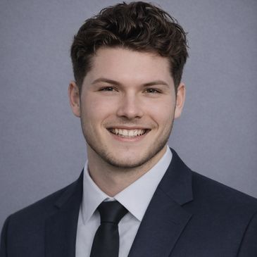 Young man in a suit smiling at the camera.