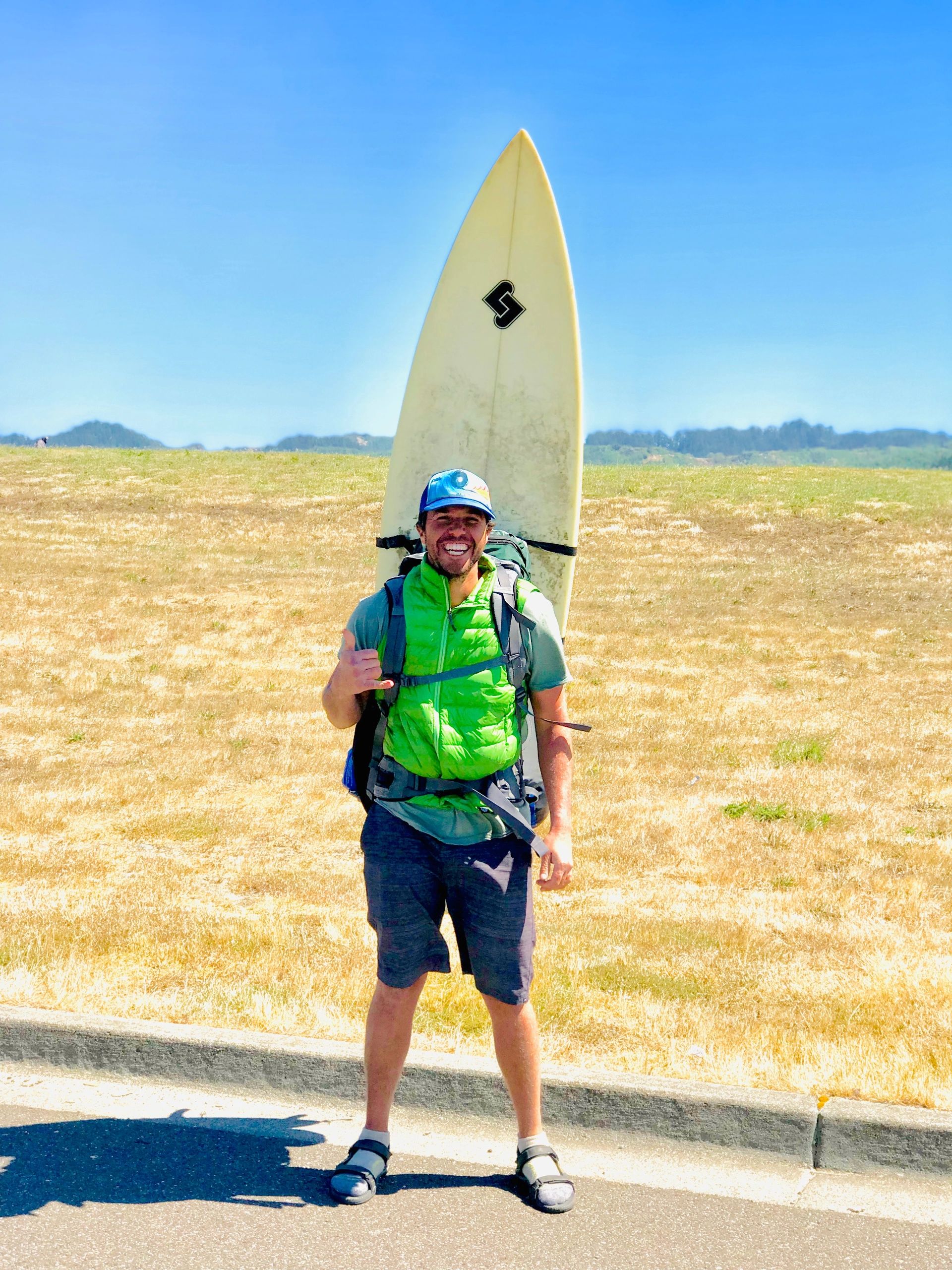 Steve, owner of Adventure Auto Repair.  Standing with backpack and surfboard Oregon Coast Trail Hike