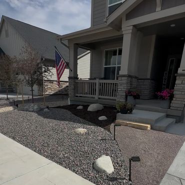 Modern house with a rock garden and American flag on the porch.