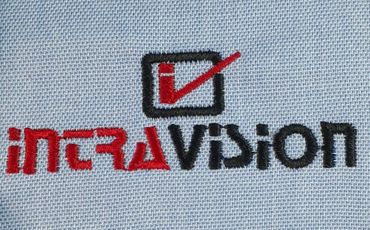 Embroidered IntraVision logo with red and black text on fabric.