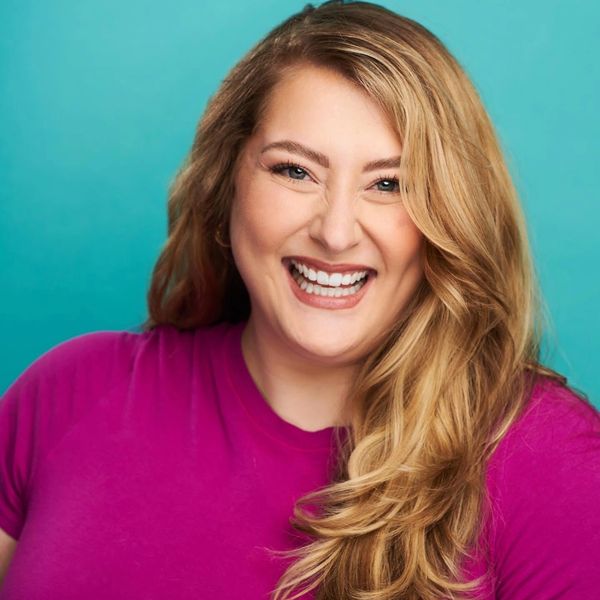 Smiling woman with long blonde hair in a magenta top.