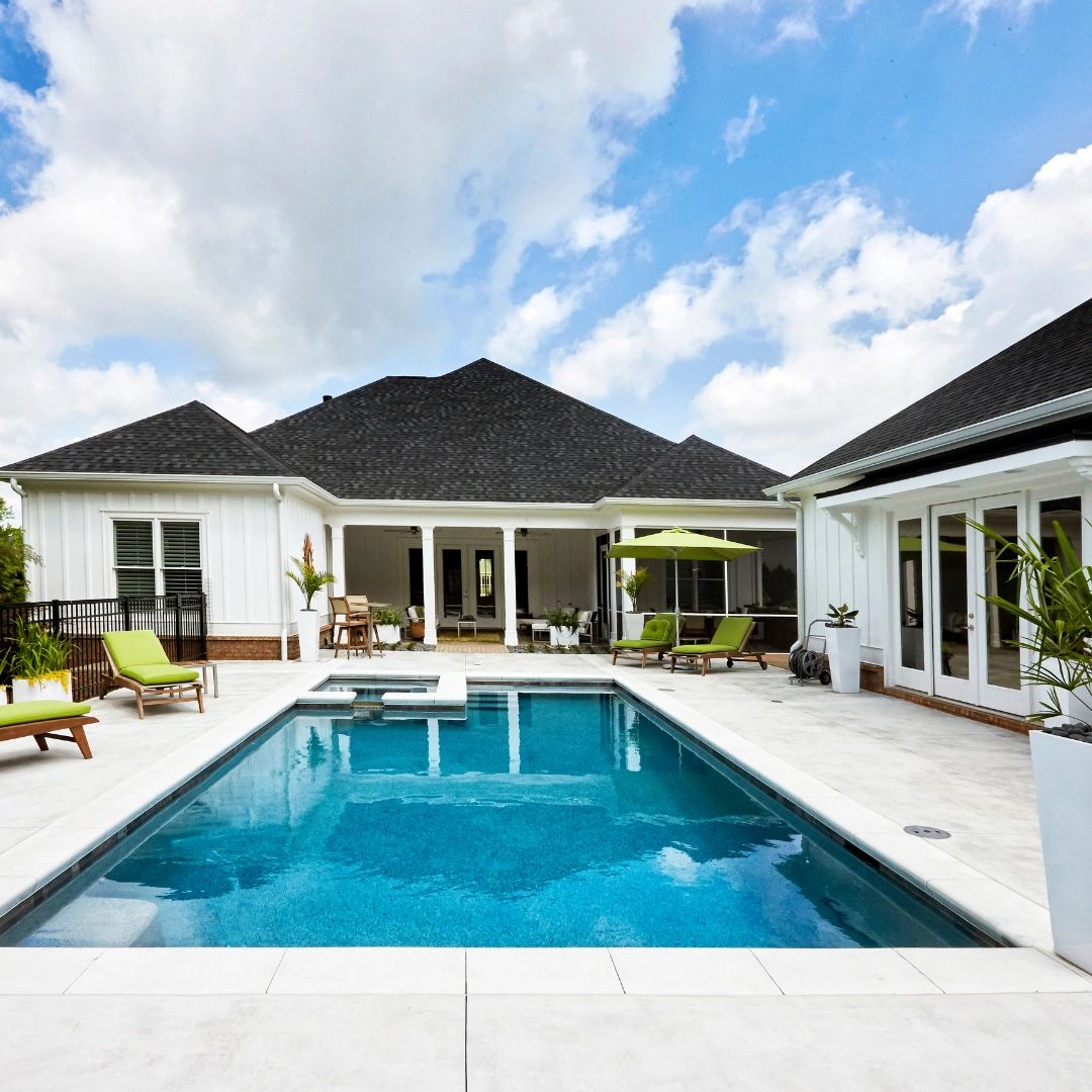 Back of a house with a pool and pool deck