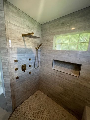 Custom walk-in shower featuring floor-to-ceiling tile.