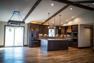 Spacious modern kitchen with dark wood cabinets and island.