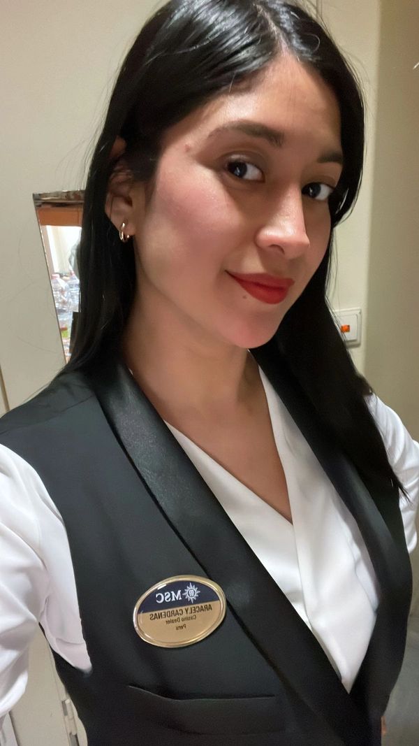 Mujer con uniforme y gafete de trabajo.