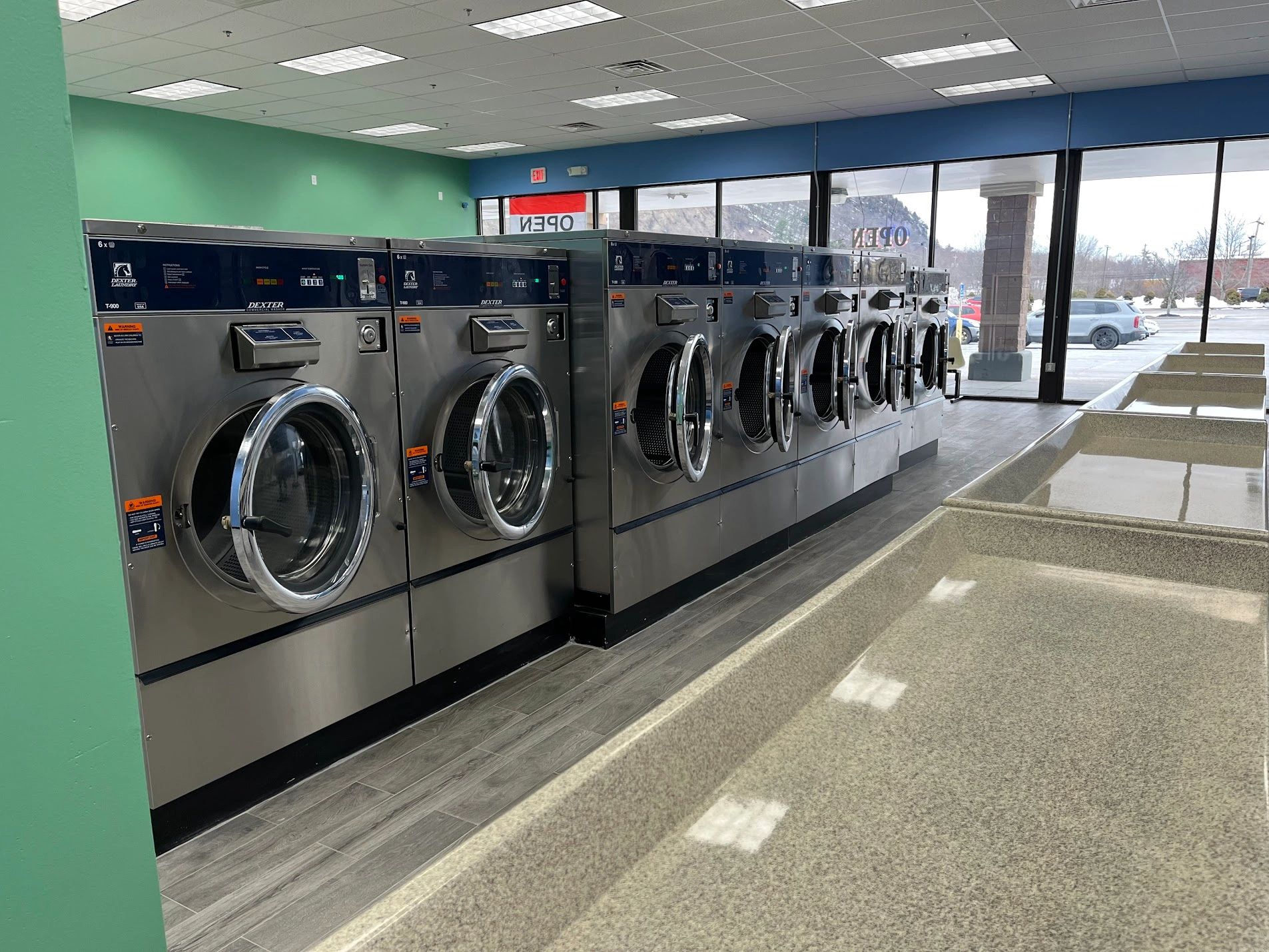 Commercial laundry machines and sinks in a laundromat.