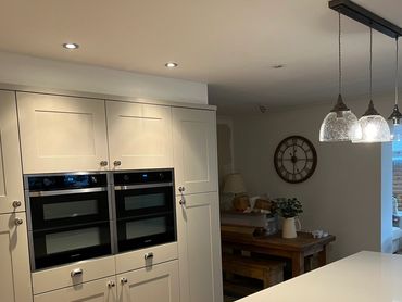 Modern kitchen with built-in ovens and pendant lighting.