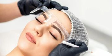 eyebrows being measured by gloved hands 