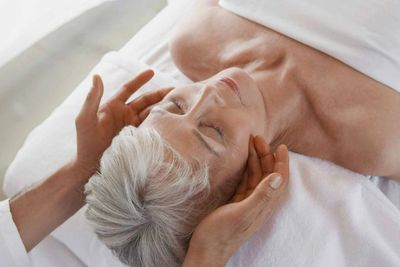 older woman receiving a facial massage  