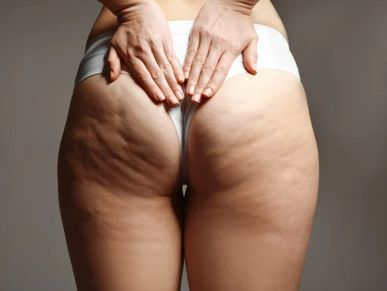 woman's buttocks' and thighs from behind, holding her tailbone  