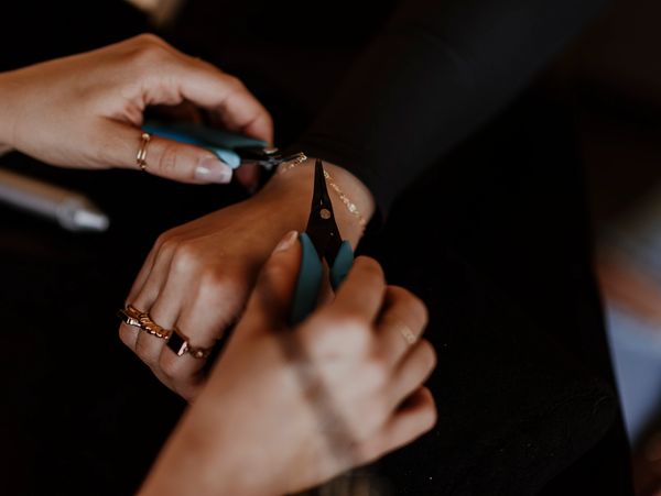 Owner of Taylored Jewelry putting a permanent bracelet on a client