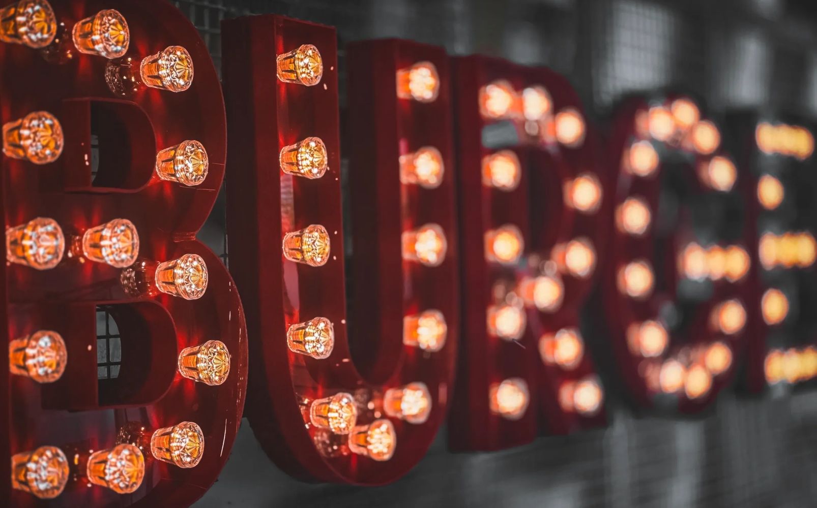 Red 3D illuminated built-up lettering in a fairground style with lights for eye-catching signage.