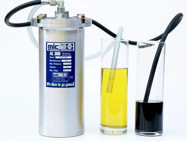 Micfil AL 300 oil and fuel filter with two glasses showing filtered and unfiltered liquid.