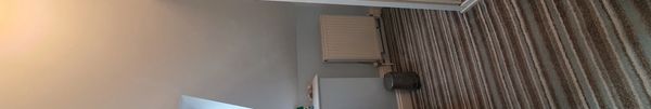 A small bathroom with a shower, toilet, sink, and striped carpet.