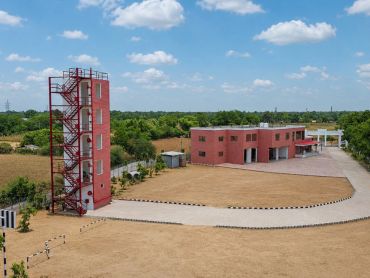 Red brick buildings in a rural area under a blue sky.