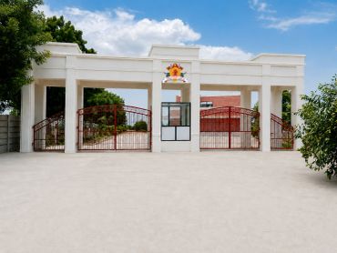 Entrance gate with white pillars and red gates.