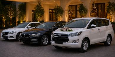 Three luxury cars parked outside a decorated building with floral accents.